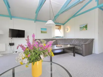 a living room with a couch and a vase of flowers at Holiday Home Momme - 500m from the sea by Interhome in Fjerritslev