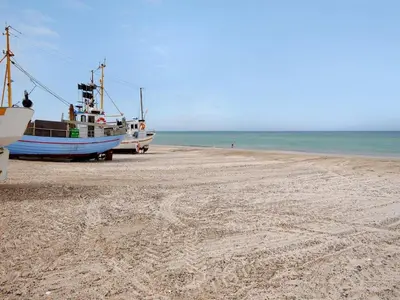 a boat sitting on a beach next to the ocean at Holiday Home Indi - 400m from the sea by Interhome in Fjerritslev