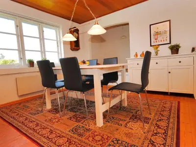 a dining room with a table and chairs on a rug at Holiday Home Indi - 400m from the sea by Interhome in Fjerritslev