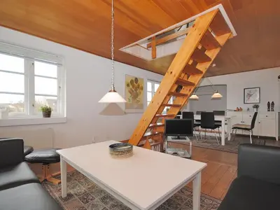 a living room with a white table and a staircase at Holiday Home Indi - 400m from the sea by Interhome in Fjerritslev