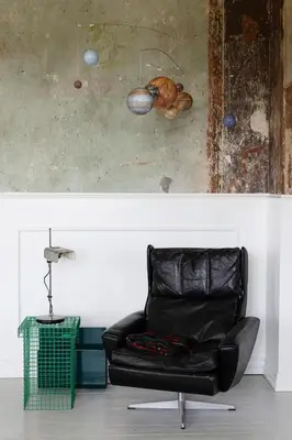 a black leather chair in a room with a wall at 18b Ferielejlighed in Harboør