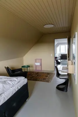 a bedroom with a bed and a desk and chairs at 18b Ferielejlighed in Harboør