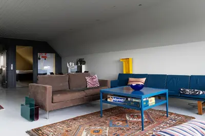 a living room with a couch and a blue table at 18b Ferielejlighed in Harboør