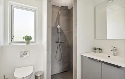 a bathroom with a shower and a toilet and a sink at Awesome Home In Løgstrup With Kitchen in Løgstrup