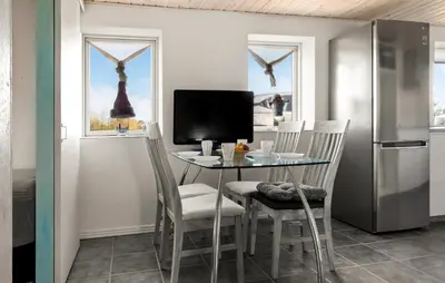 a kitchen with a table with chairs and a television at 2 Bedroom Nice Home In Bedsted Thy in Bedsted Thy