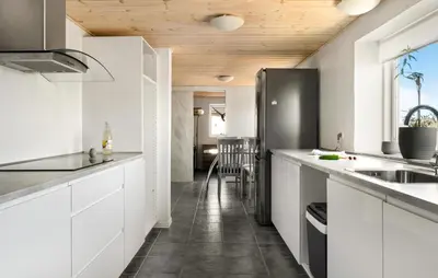 a kitchen with white cabinets and a black refrigerator at 2 Bedroom Nice Home In Bedsted Thy in Bedsted Thy