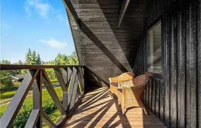 a wooden porch with a bench on the side of a house at 2 Bedroom Gorgeous Apartment In Blokhus in Blokhus