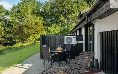 a patio with a table and chairs on it at 2 Bedroom Gorgeous Apartment In Blokhus in Blokhus