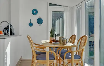 a dining room with a table and four chairs at 2 Bedroom Gorgeous Apartment In Blokhus in Blokhus