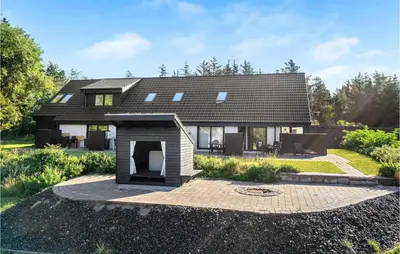 a house with a dog house in front of it at 2 Bedroom Gorgeous Apartment In Blokhus in Blokhus