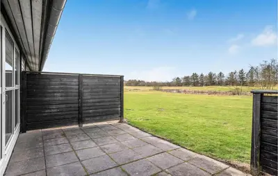 a gate on the side of a house with a field at 2 Bedroom Cozy Apartment In Pandrup in Pandrup