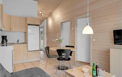 a kitchen and living room with a table and chairs at 2 Bedroom Cozy Apartment In Pandrup in Pandrup