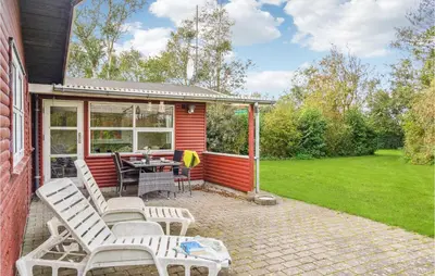 a patio with a table and chairs on a house at Cozy Home In Vinderup With Kitchen in Vinderup