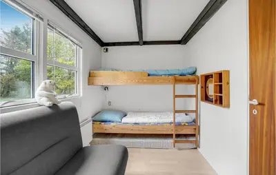 a room with bunk beds and a couch and a window at Cozy Home In Vinderup With Kitchen in Vinderup