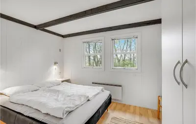a white bedroom with a bed and two windows at Cozy Home In Vinderup With Kitchen in Vinderup