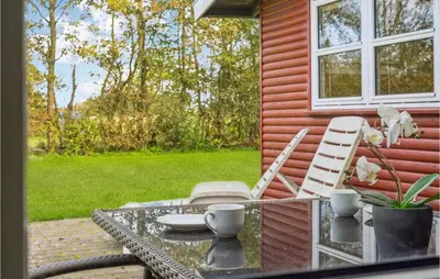 a patio with a table and chairs and a window at Cozy Home In Vinderup With Kitchen in Vinderup