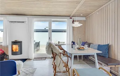 a dining room with a table and a view of the ocean at Amazing Home In Pandrup With Kitchen in Pandrup