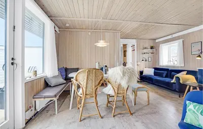a living room with a table and chairs at Amazing Home In Pandrup With Kitchen in Pandrup