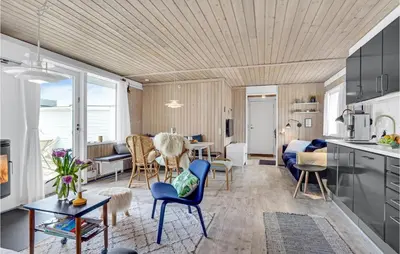 a kitchen and living room with a table and chairs at Amazing Home In Pandrup With Kitchen in Pandrup