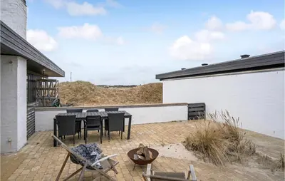 a patio with a table and chairs next to a building at Amazing Home In Pandrup With Kitchen in Pandrup