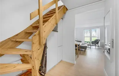 a wooden staircase in a white room with a dining room at Cozy Home In Lemvig With Wifi in Lemvig