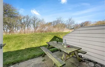 a picnic table on a patio next to a building at Cozy Home In Lemvig With Wifi in Lemvig