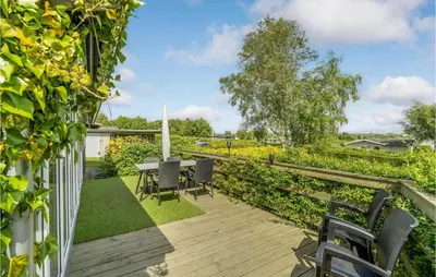 a patio with a table and chairs in a garden at Stunning Home In Roslev With Kitchen in Roslev