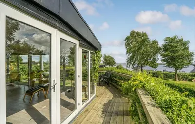 a house with sliding glass doors on a deck at Stunning Home In Roslev With Kitchen in Roslev