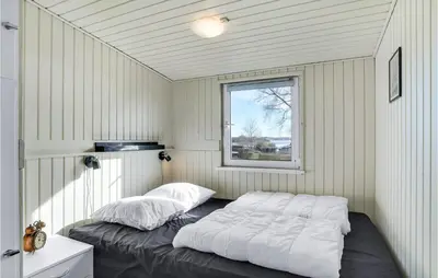 a bedroom with a bed in a room with a window at Stunning Home In Roslev With Kitchen in Roslev