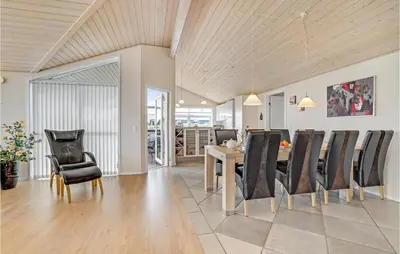 a dining room with a table and black chairs at Beautiful Home In Vinderup With Sauna in Vinderup