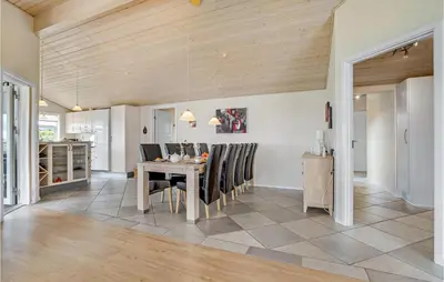 a kitchen and dining room with a table and chairs at Beautiful Home In Vinderup With Sauna in Vinderup