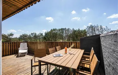 a wooden table and chairs on a wooden deck at Awesome Home In Thisted With Kitchen in Thisted