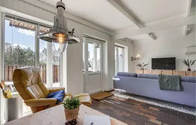 a living room with a blue couch and a tv at Awesome Home In Thisted With Kitchen in Thisted