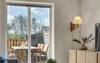 a dining room with a table and a sliding glass door at Awesome Home In Thisted With Kitchen in Thisted