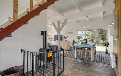 a living room with a wood stove and a table at Awesome Home In Thisted With Kitchen in Thisted