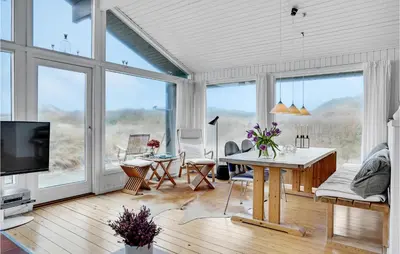 a living room with a table and a large window at Beautiful Home In Pandrup With Wifi in Pandrup
