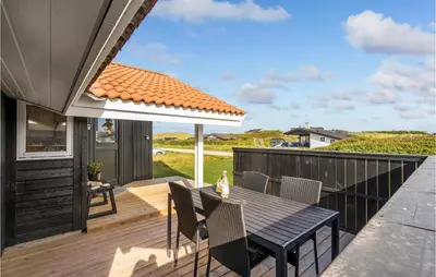 a patio with a table and chairs on a deck at 3 Bedroom Stunning Home In Thisted in Thisted