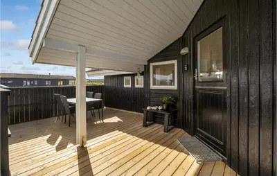 a wooden deck with a table and chairs on a balcony at 3 Bedroom Stunning Home In Thisted in Thisted