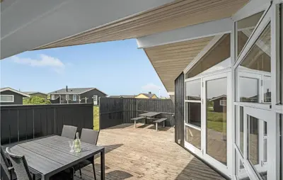 a patio with a table and chairs on a deck at 3 Bedroom Stunning Home In Thisted in Thisted