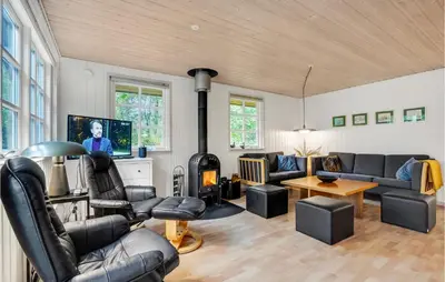 a living room with black leather furniture and a tv at Amazing Home In Thyholm With Wifi in Thyholm