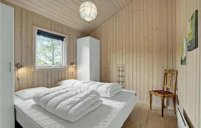 a large white bed in a room with a window at Cozy Home In Hurup Thy With Sauna in Sønder Ydby