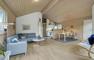 a living room with a couch and a table at Cozy Home In Hurup Thy With Sauna in Sønder Ydby
