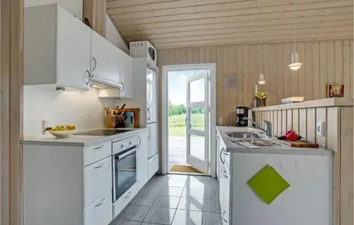 a kitchen with white appliances and an open door at Cozy Home In Hurup Thy With Sauna in Sønder Ydby