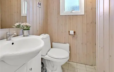 a bathroom with a white toilet and a sink at Nice Home In Hanstholm With Kitchen in Hanstholm