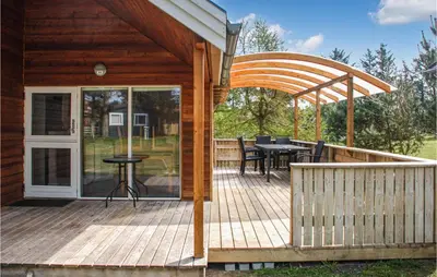 a wooden deck with a table and chairs on it at Nice Home In Hanstholm With Kitchen in Hanstholm