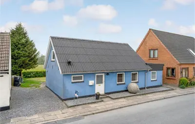 a blue house with a black roof on a street at Gorgeous Home In Nykøbing M With Wifi in Tødsø