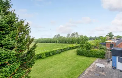 a garden with a lawn and trees and a table at Gorgeous Home In Nykøbing M With Wifi in Tødsø