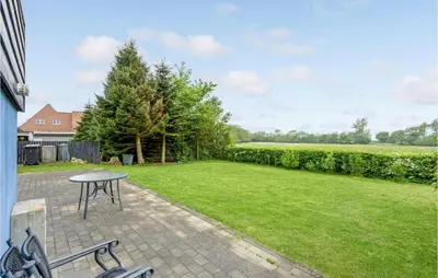 a patio with a table and a lawn at Gorgeous Home In Nykøbing M With Wifi in Tødsø
