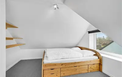a bedroom with a wooden bed with a window at Gorgeous Home In Nykøbing M With Wifi in Tødsø