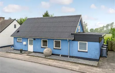 a blue house with a black roof on a street at Gorgeous Home In Nykøbing M With Wifi in Tødsø